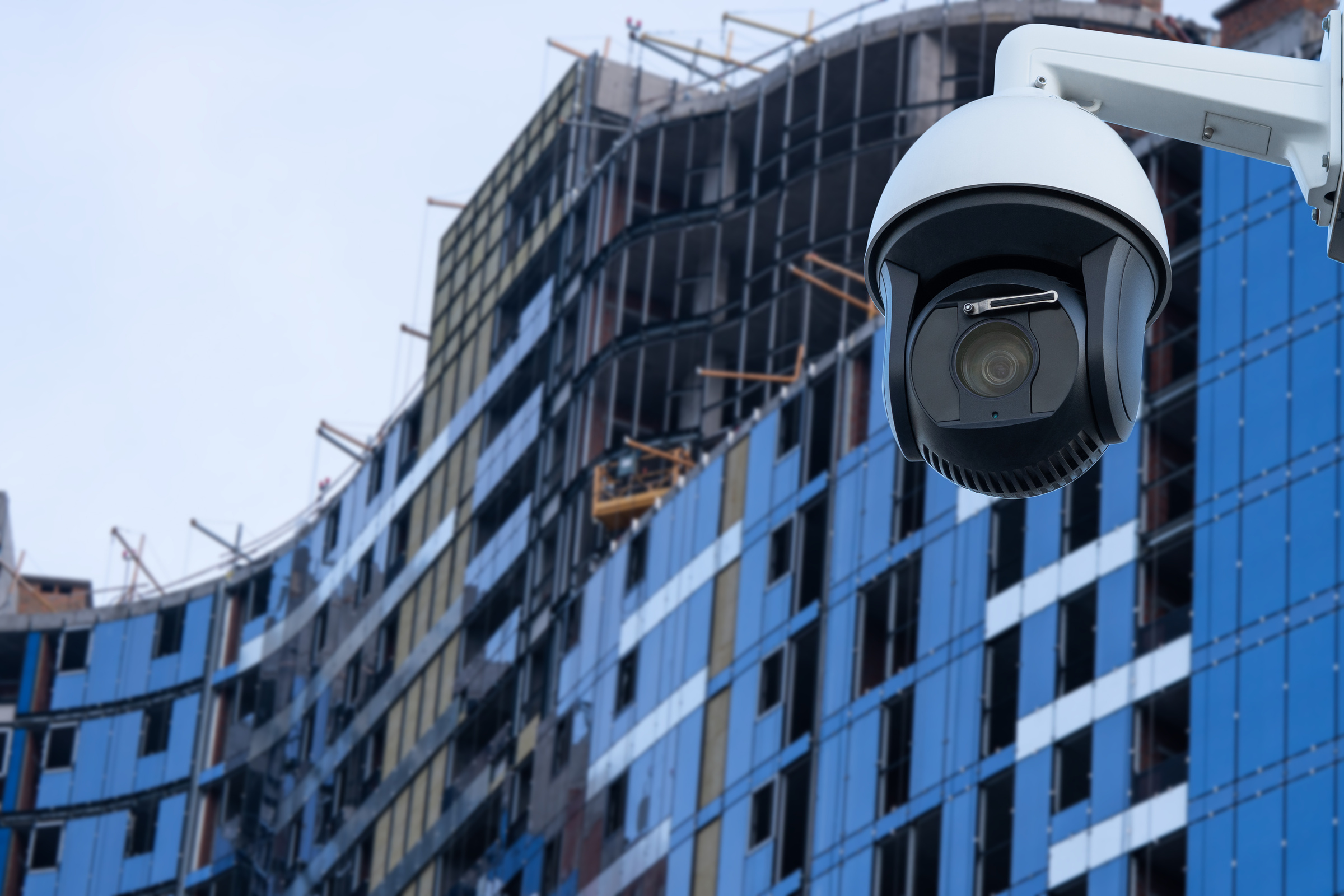 security CCTV camera or surveillance system with construction site on blurry background.
